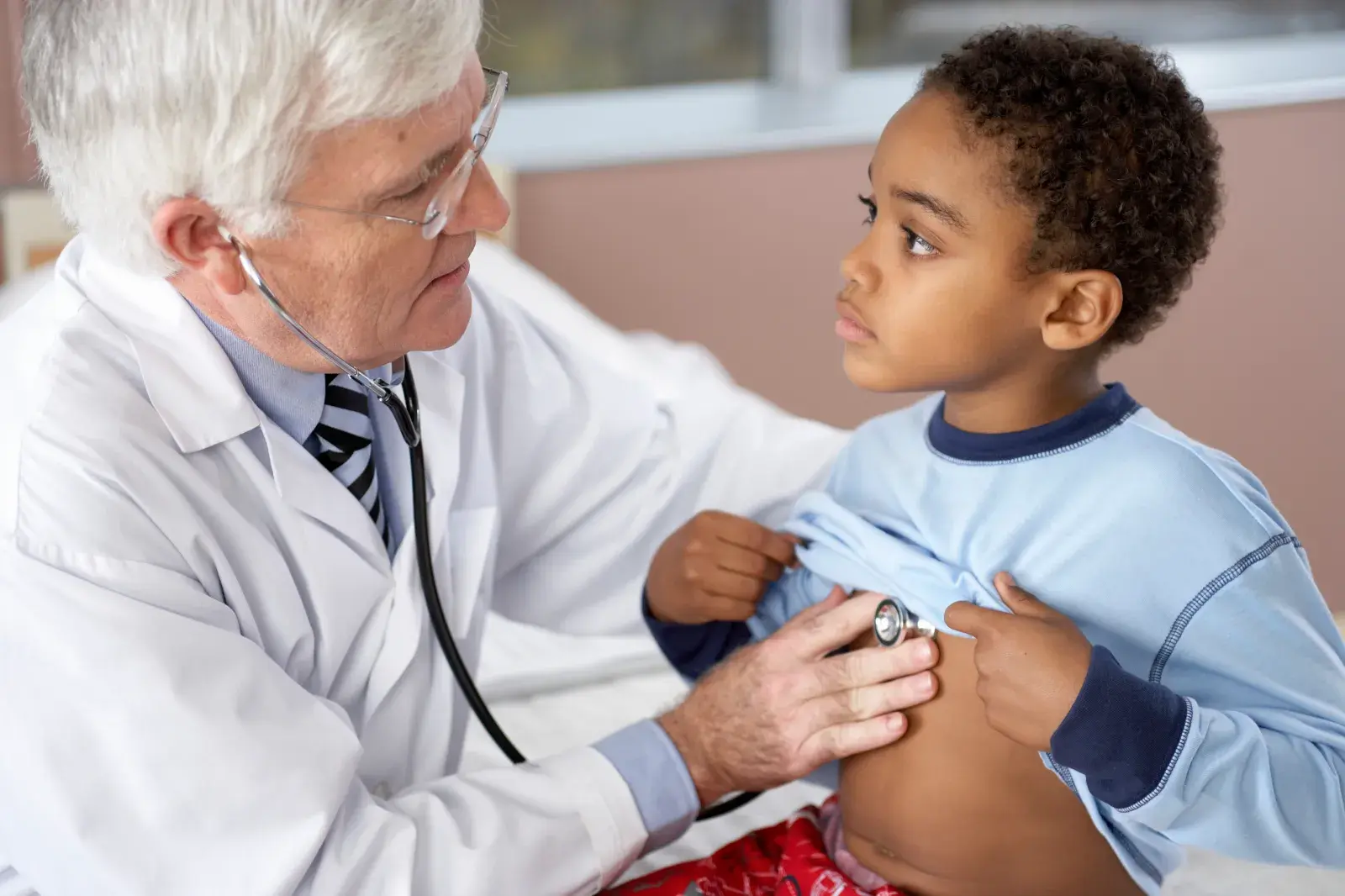 A young boy being examined by a doctor.